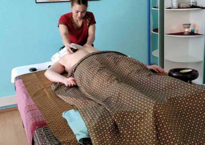 Behandlung Thaimassage mit Hot Stone auf der Massageliege